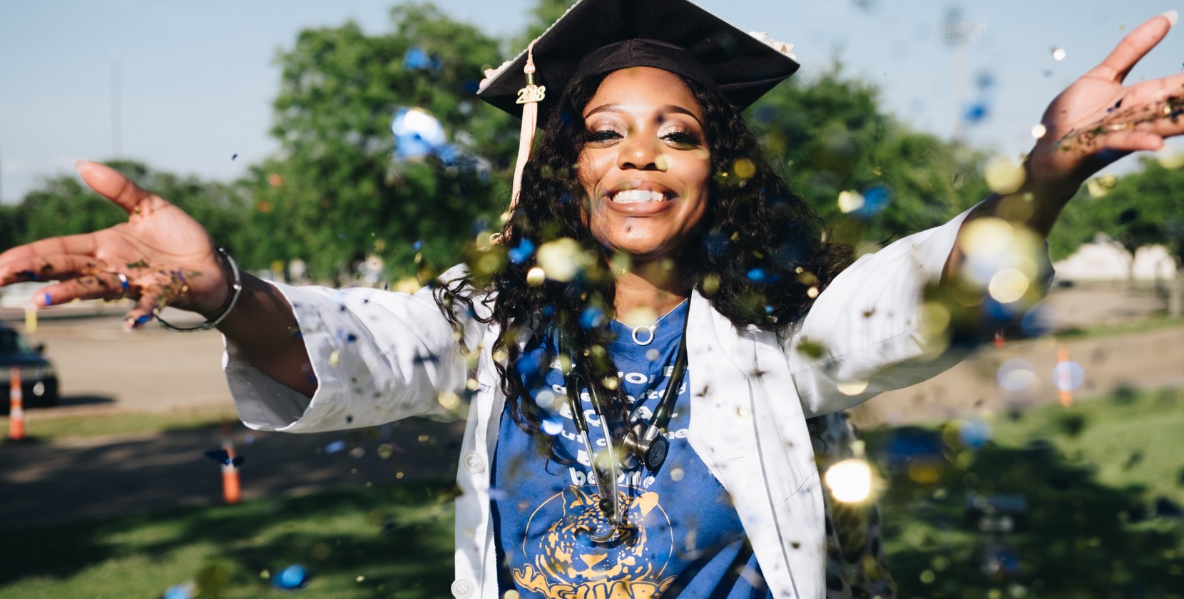 A widescreen photograph of a medical student celebrating their graduation from university.